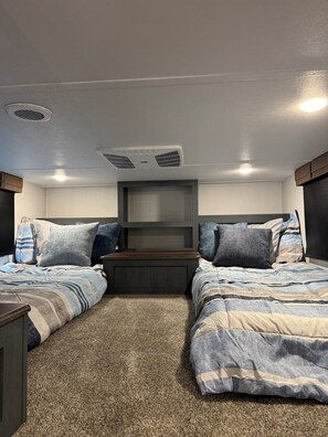 Ein Schlafzimmer mit zwei Betten, einer Kopfteil und einem Teppichboden.
