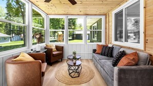 A sunroom with large windows, wooden ceiling, and a ceiling fan. - Lakeside Lodge - Game Cave, Golf Greens! Sleeps 17 (Gladwin)