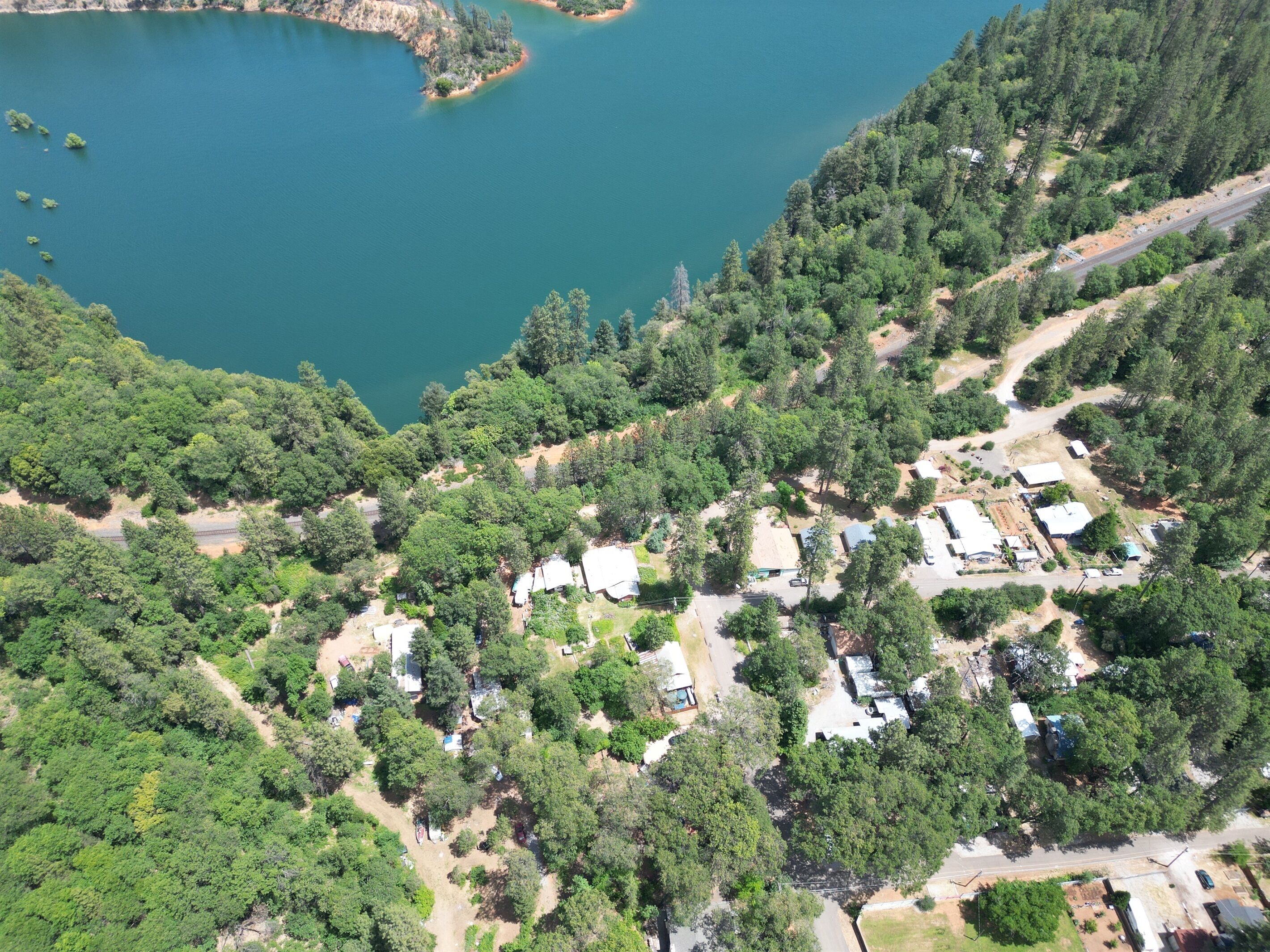 Vista aérea de una zona residencial con casas, una carretera y un lago.