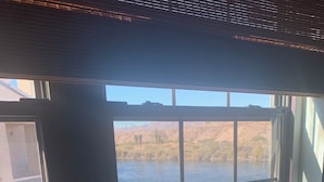 A window with a view of a body of water and distant hills. - Riverfront 2 bed/2.5 bath Condo w/ Pool & Spa, River Dock - Small Dogs OK! (Bullhead City)