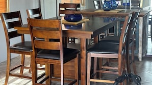 A dining area with wooden chairs and a table, a blue pitcher, and a framed artwork on the wall. - Riverfront 2 bed/2.5 bath Condo w/ Pool & Spa, River Dock - Small Dogs OK! (Bullhead City)