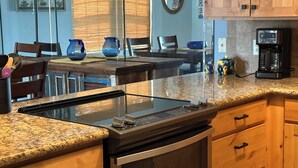 A kitchen with granite countertops, wooden cabinets, a built-in oven, and a coffee maker. - Riverfront 2 bed/2.5 bath Condo w/ Pool & Spa, River Dock - Small Dogs OK! (Bullhead City)