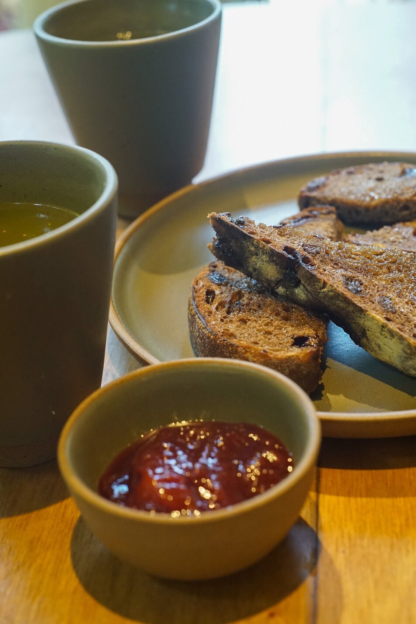 Une assiette avec des tranches de pain et un petit bol de confiture.