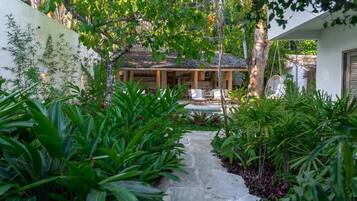 A pathway leading to a house with a covered porch and outdoor furniture.