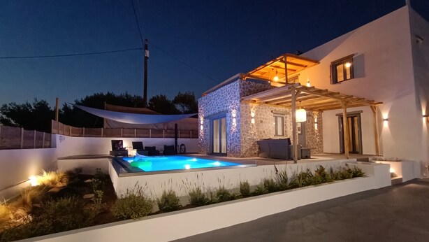 A modern house with a swimming pool, outdoor seating, and a pergola.