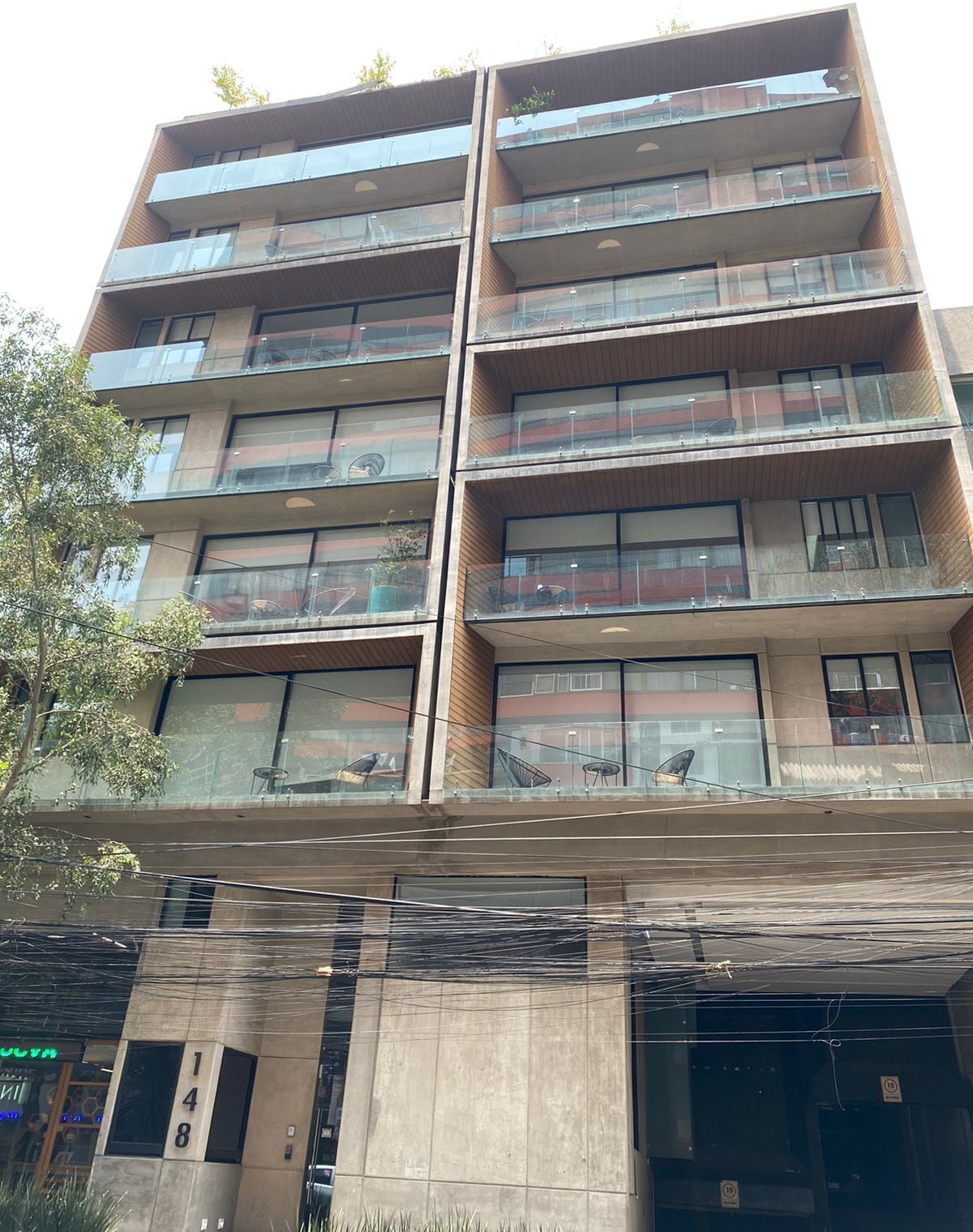 A multi-story building with balconies, large windows, and a concrete facade.