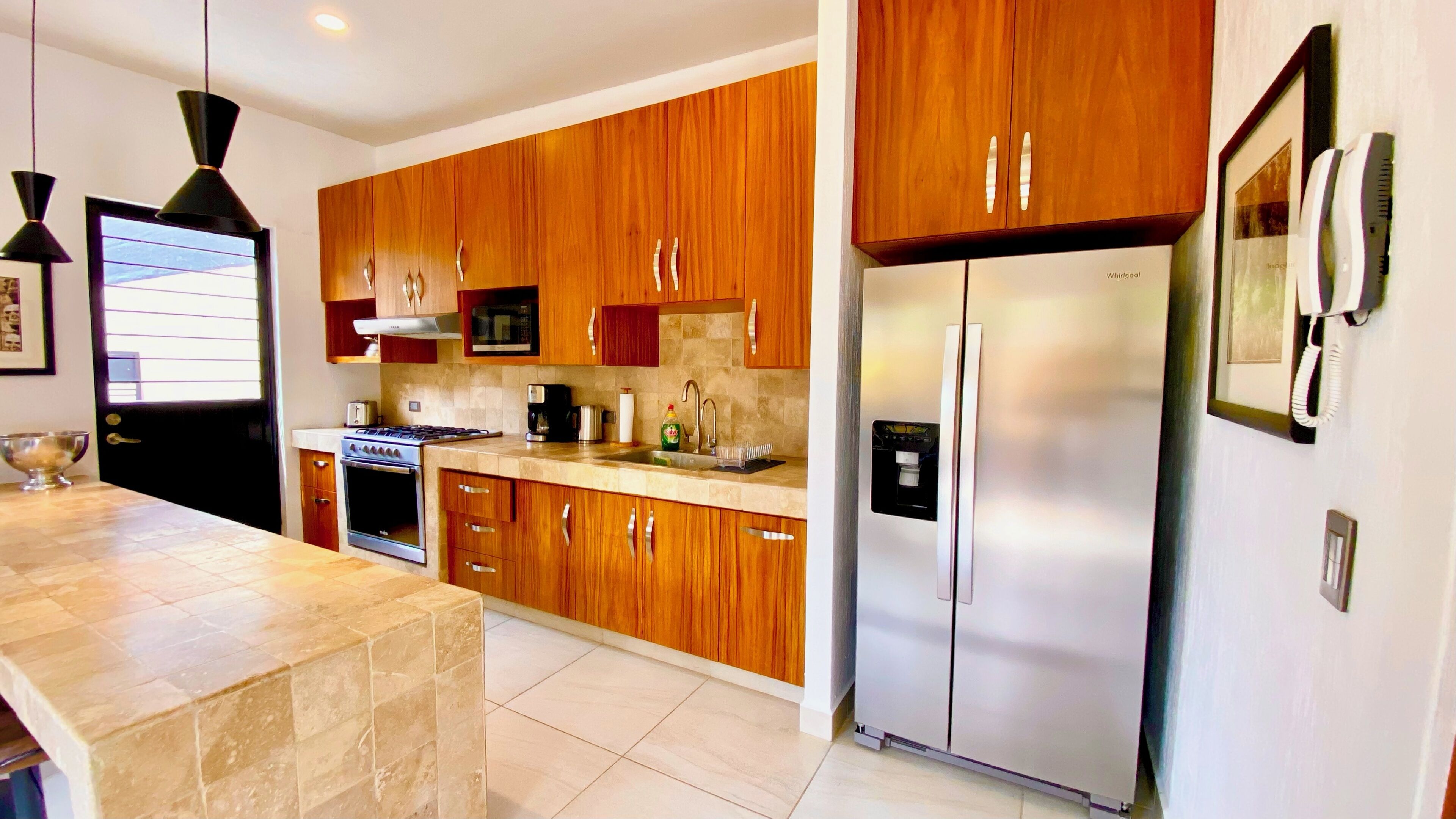A modern kitchen with wooden cabinets, stainless steel appliances, and a built-in oven.