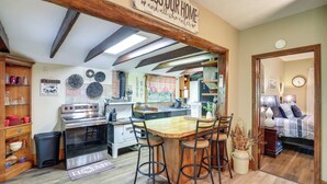 A kitchen with a wooden bar, a stove, and a sign above the bar that reads "Bless Our Home". - Cozy Mars Hill Farmhouse w/ Scenic Views (Mars Hill)