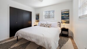 A bedroom with a large bed, two bedside tables with lamps, a ceiling fan, and two wall-mounted paintings. - GameRoom, Trail access seconds away, cozy! (Bella Vista)