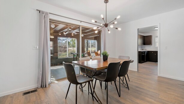 A modern dining area with a large wooden table, four chairs, and a ceiling light fixture. - GameRoom, Trail access seconds away, cozy! (Bella Vista)