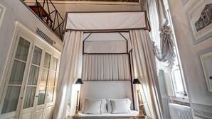 A bedroom with a canopy bed, a wooden desk, and a patterned floor. - YID Bargello luxury suite (Firenze)