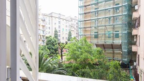 A view from a balcony overlooking a cityscape with multi-story buildings, some with scaffolding, and lush greenery. - Cosy Vatican Apartment (Roma)