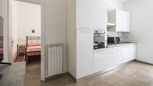 A modern kitchen with white cabinets, a built-in oven, and a microwave. - Cosy Vatican Apartment (Roma)