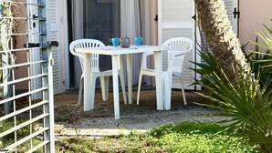 Un patio con una mesa, sillas, un portón y una palmera.