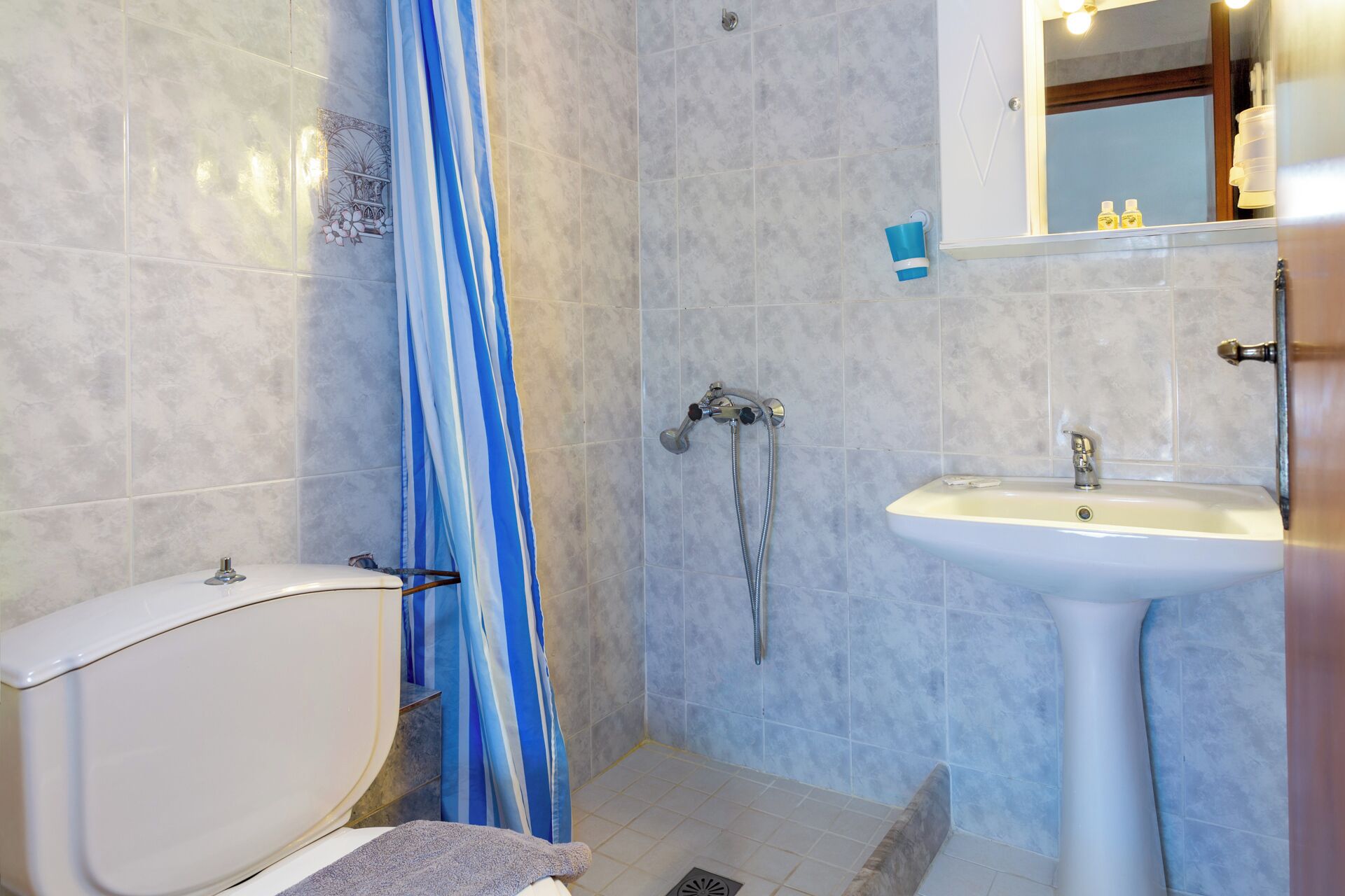 A bathroom with a shower, toilet, and sink.