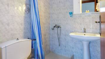 A bathroom with a shower, toilet, and sink.
