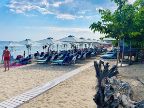 Sulla spiaggia, sabbia bianca, lettini da mare, ombrelloni