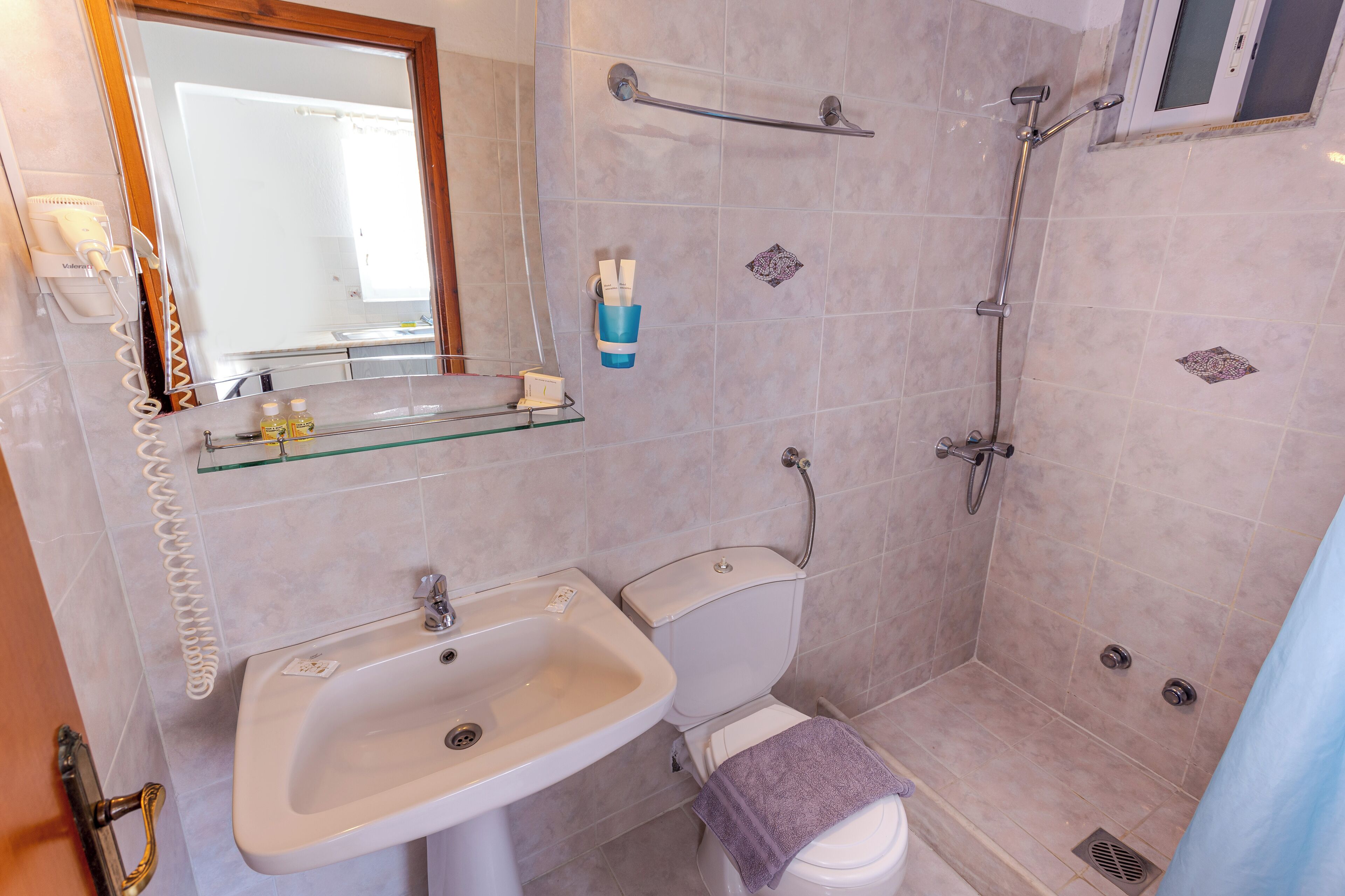 A bathroom with a sink, toilet, and shower.