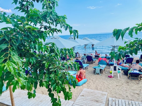 On the beach, white sand, sun loungers, beach umbrellas