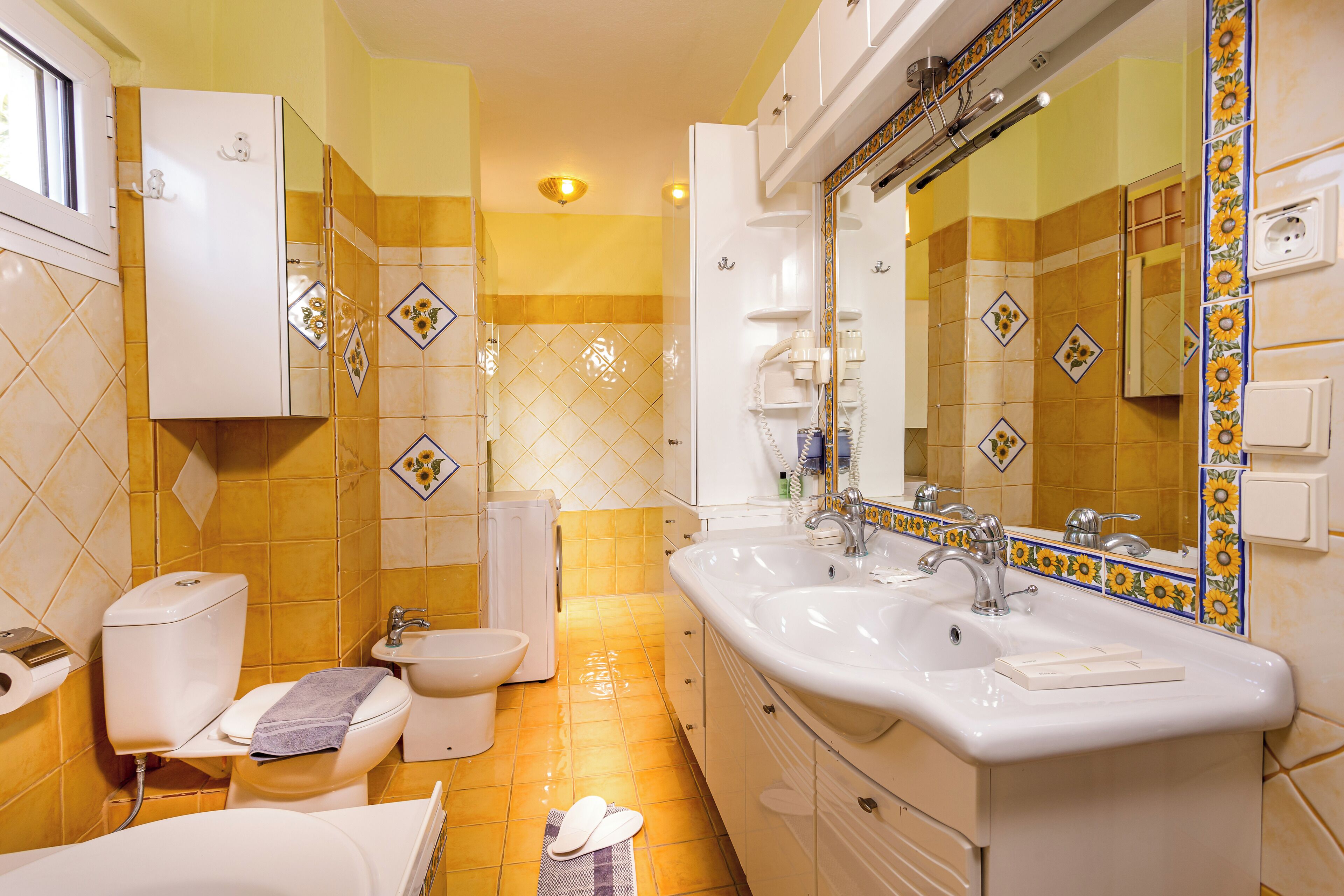 A bathroom with a toilet, bidet, sink, and bathtub.