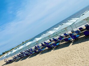 Sulla spiaggia, sabbia bianca, lettini da mare, ombrelloni