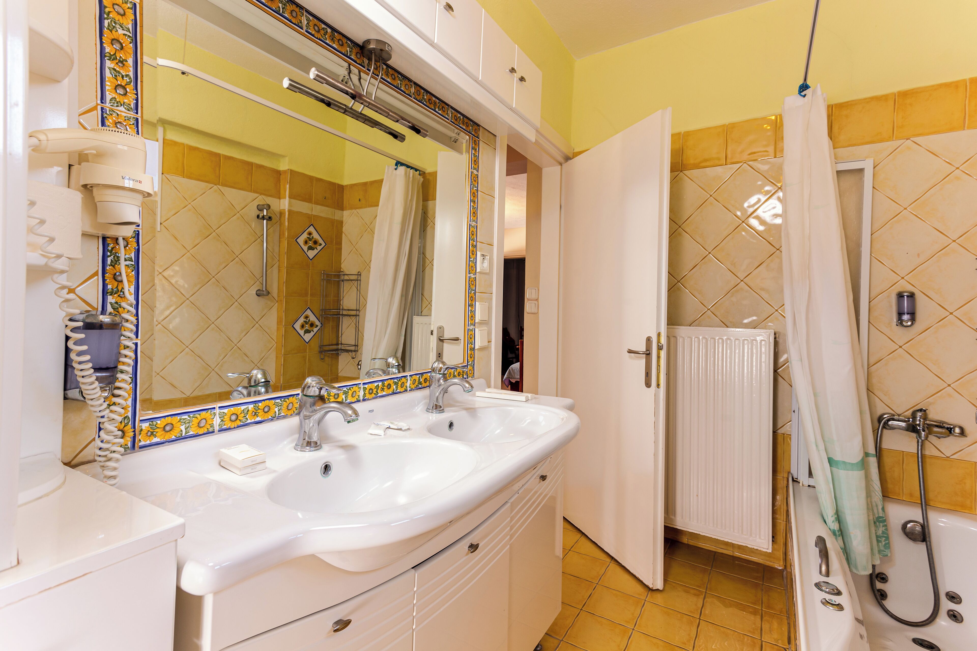 A bathroom with two sinks, a shower, and a toilet.