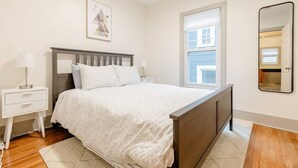 A bedroom with a bed, nightstands, a window, and a mirror. - Gates Circle 2 Bedroom Sanctuary (Buffalo)
