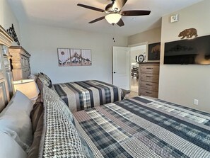 A bedroom with a bed, a ceiling fan, a dresser, a clock, and a wall-mounted picture. - Legacy at the Summit - 2 Balconies, Mountain Views, Walk Downtown (Gatlinburg)