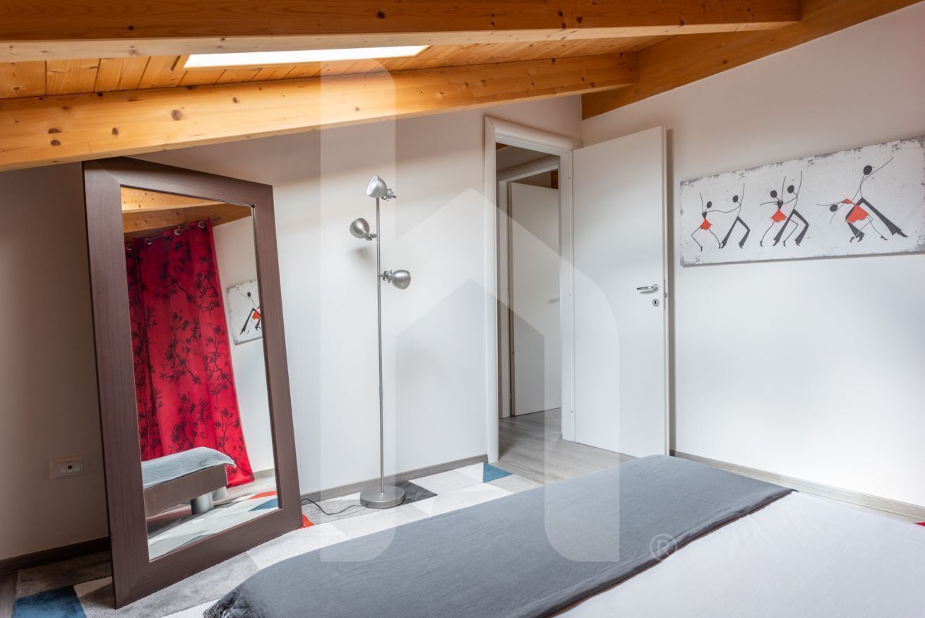 Une chambre à coucher avec un lit, une douche et une porte donnant sur une autre pièce.