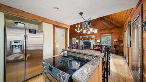 A modern kitchen with stainless steel appliances, granite countertops, and a central island. - Cherokee Winds - 2bd 3bth in Chalet Village w/ Mountain Vews! (Gatlinburg)