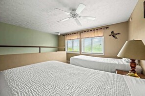 A hotel room with two beds, a ceiling fan, a window with blinds, and a wall-mounted lamp. - Sleeps 8 Pool Playground Mountain Views Hot Tub (Gatlinburg)