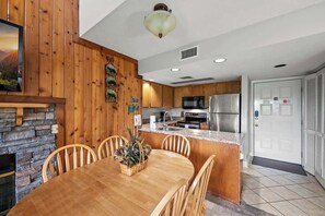 Une cuisine moderne avec des meubles en bois, un plan de travail en granit et des appareils électroménagers en acier inoxydable.