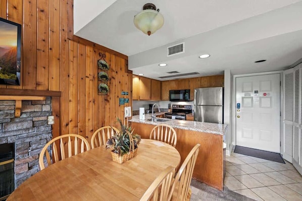 A modern kitchen with wooden cabinets, a granite countertop, and stainless steel appliances.