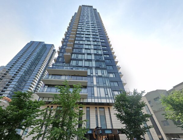 A modern high-rise building with multiple floors, large windows, and balconies. - Sky Palace (Calgary)