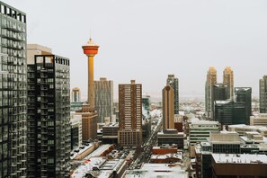 A cityscape with tall buildings, a prominent tower, and a busy street. - Sky Palace (Calgary)