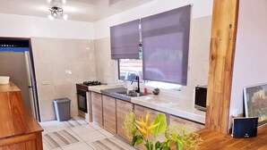 Una cocina moderna con encimera de madera, un fregadero y una ventana con persianas.