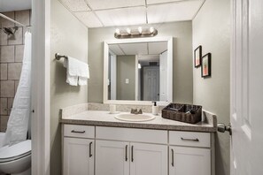 A bathroom with a sink, mirror, and towel rack. - Vivid 1BD: TCU Walkable, Inspiring & Restful! (Fort Worth)