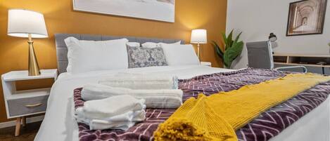 2 habitaciones, escritorio y tabla de planchar con plancha