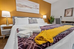 Een hotelkamer met een bed, twee nachtkastjes, een bureau en een stoel.