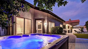 A hot tub in a backyard with a house in the background.