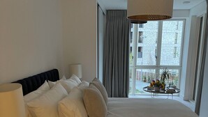 A hotel room with a large bed, a bedside table with a lamp, and a view of the outside balcony. - Modern apartment in the heart of London.  (London)