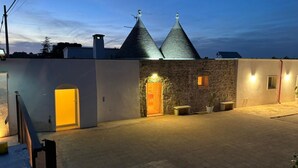 A building with a stone facade, a wooden door, and two conical roofs. - GuestHost - Trulli Miriam: Enchanting Apulian Getaway (Martina Franca)