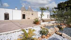 A stone building with a courtyard, white walls, and a clear sky. - GuestHost - Trulli Miriam: Enchanting Apulian Getaway (Martina Franca)