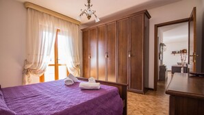 Un dormitorio con cama, armario y espejo.