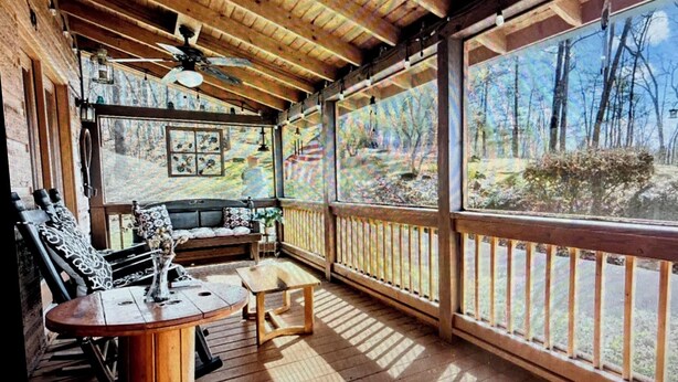 A wooden deck with a ceiling fan, a round table, and a sofa. - Peaceful Blue Ridge Mtn Cabin-Gated, WiFi, Hot Tub, Fire Pit, Game Room (Blue Ridge)
