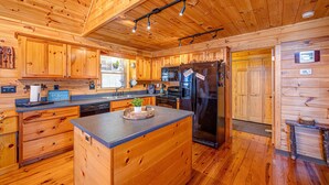 A wooden cabin kitchen with a central island, built-in appliances, and a rustic design. - Peaceful Blue Ridge Mtn Cabin-Gated, WiFi, Hot Tub, Fire Pit, Game Room (Blue Ridge)