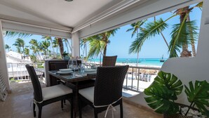A dining area with a view of the beach and ocean.