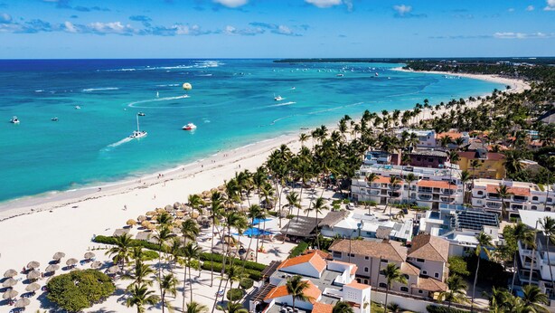 A coastal resort with beachfront villas, clear turquoise waters, and a sandy beach.