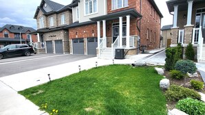A residential area with two-story houses, a well-maintained lawn, and a street with parked cars. - Spacious 4 Bedroom House in Angus (Angus)