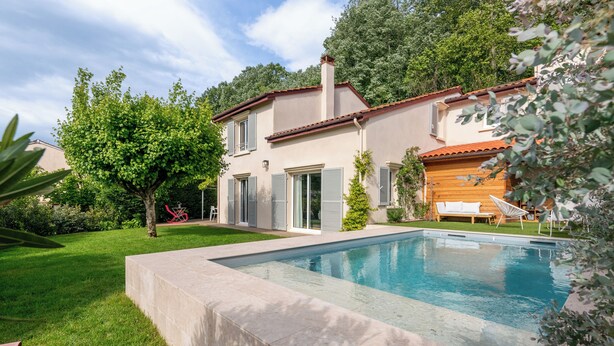 A modern house with a swimming pool, a well-maintained lawn, and a wooden deck. - Villa Juliette - Welkeys (Écully)